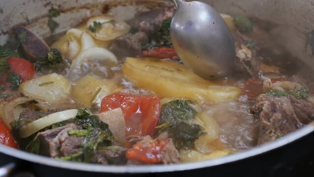 the process of cooking real Armenian khashlama with lamb meat, potatoes, tomatoes, peppers and onions. Boiling soup slow motion. National Armenian and Georgian food