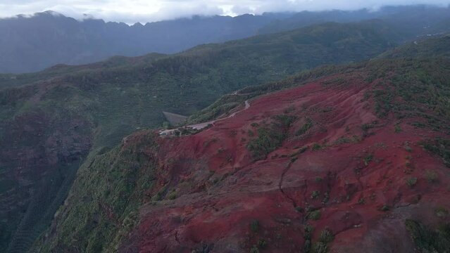 Aerial view of stunning viewpoint Mirador de Abrante with glass observation balcony above Agulo village in La Gomera island at sunrise. Restaurant on red clay