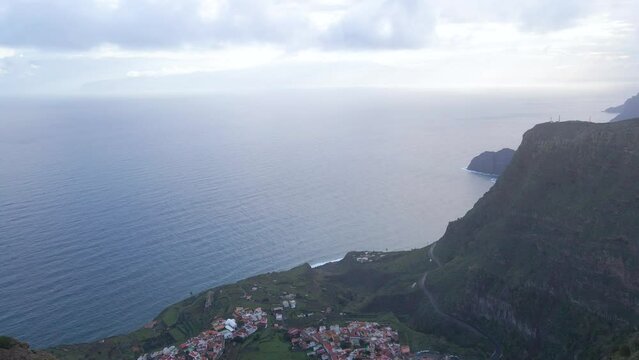 Aerial view of stunning viewpoint Mirador de Abrante with glass observation balcony above Agulo village in La Gomera island at sunrise. Restaurant on red clay