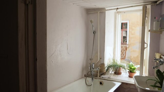 in the old Sovdepovskaya bathroom, a cast-iron bathtub is filled with water