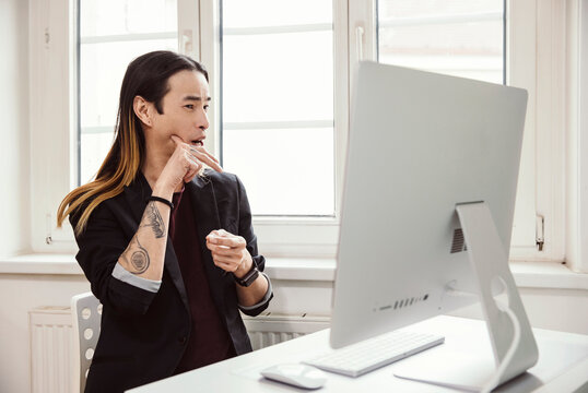 Mid adult man using sign language in front of computer