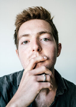 Studio portrait of young man covering mouth