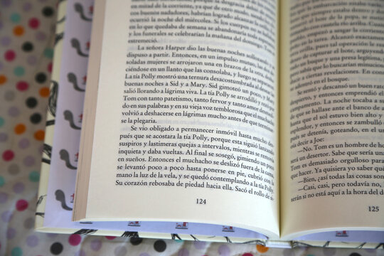 Open book. Reading. Literature. Spanish writing. Classic novel. Letters, paragraphs and lines. Black and white print. Pages of a book. Sheets. Close up. Text. Education. Tom Sawyer. Mark Twain Spanish