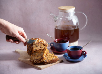 a female hand attacks a brown cupcake with candied fruit for breakfast,