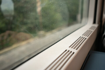Train window with raindrops and heating system in the interior of a European train. High quality photo - 505787074