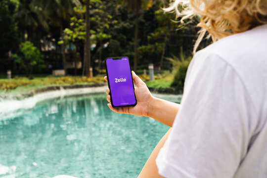 Girl In The Park Holding A Smartphone With Zelle Instant Payment System App On The Screen. Rio De Janeiro, RJ, Brazil. May 2022