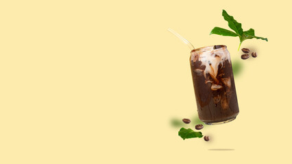 Floating can-shaped glass cup with coffee, coffee beans, coffee leaves flying on a yellow...