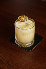 Fruit mixology with mezcal and dry lime on wooden table topper. Warm colored cocktails. Mezcal cocktail.