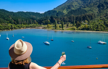 woman toasts New Zealand inlet from cruise ship