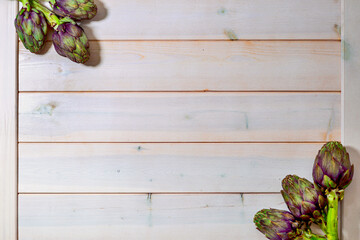Artichoke flowers, purple edible bud on wooden board background