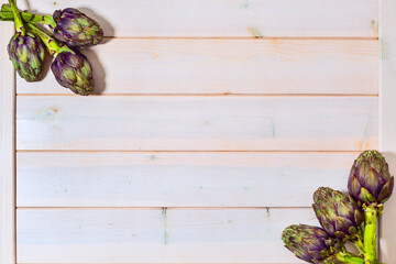 Artichoke flowers, purple edible bud on wooden board background