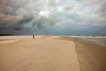 Fototapeta na wymiar Praia do Norteste brasileiro, uma pessoa distante na areia da praia.