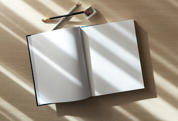 open book with blank pages and pencils