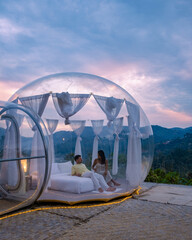 Bubble dome tent glamping in the mountains of, Transparent bell tent with comfortable bed and pillow in the forest, glamping hotel, luxury travel, glamourous camping.  - obrazy, fototapety, plakaty