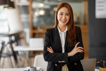 Charming Smiling Asian businesswoman a smile standing and looking at the camera over office background