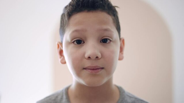 Portrait of ten year old hispanic boy with expectant, curious expression on face