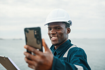 Optimistic African American worker making video call near sea