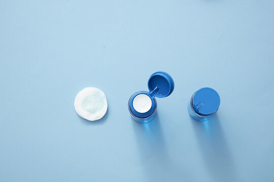 Top View Of Makeup Remover Water And Cotton Pad In Blue Background 