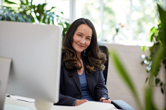 Professional Business Woman Sitting At A Desk With A Computer