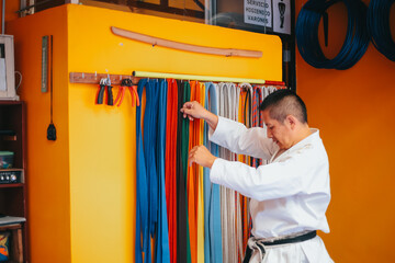 Karateka ordenando sus accesorios de entrenamiento en un dojo. Concepto de deportes y artes...