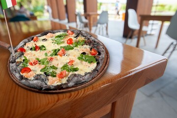 Italian pizza with on wooden round desk.