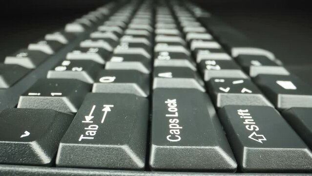A finger pressing the capslock button on the side of the keyboard in Estonia