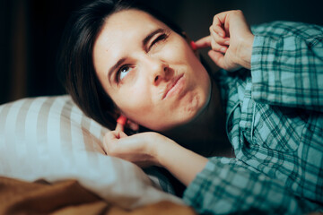 Stressed Woman Using Ear Plugs Trying to Sleep