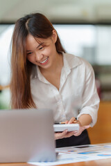 Portrait of Business woman hand using calculator to calculate the company's financial results and budget. Account Audit Concept.