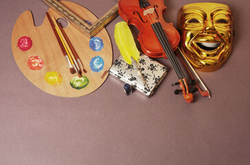 Attributes of arts. Music, literature, painting, poetry, theater. A violin with a bow, a notebook...