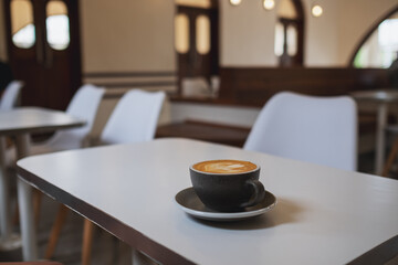 A cup of hot latte coffee on the table in cafe