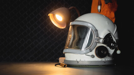 Concept of astronaut helmet on the table of the orbital station background.