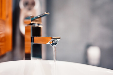 Water tap , faucet. Flow water in bathroom with sink. Modern clean hause. Hygiene concept. Panorama - obrazy, fototapety, plakaty