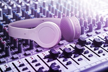 Headphone on purple mixing console. Recording concept