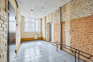 The long beige corridor with brick walls