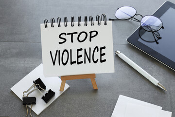 Stop Violence text on an open notebook on a stand. gray background - obrazy, fototapety, plakaty
