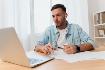 Fototapeta premium Concentrated pensive good-looking young businessman meeting using laptop app video conference communication in office. Copy space for ad. Remote Job, Technology And Career Profession Concept
