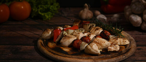 Shish kebab with cherry tomato and sweet pepper and onions on wooden plate. Barbecue, food, holiday concept