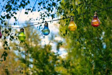 String of lights hanging on the tree. Garden party. Romantic place. Colorful light