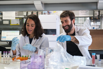 Two young phD students working in a real laboratory analysing experimental samples.
