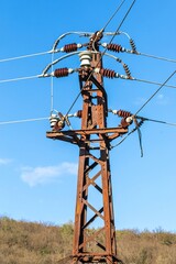 Old rusty electricity supply. High voltage power line. Electricity pole and wires on a sky...