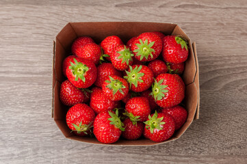 frische Erdbeeren in einer Schale auf einer Holzplatte in der Küche