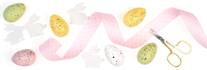 Composition of the diy elements for easter decoration as eggs, ribbon, paper rabbits, scissors on isolated white background