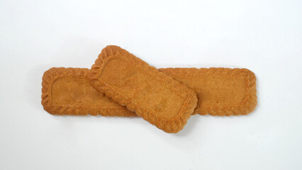 Pile of caramel and spice flavors (speculoos) biscuits isolated on white background