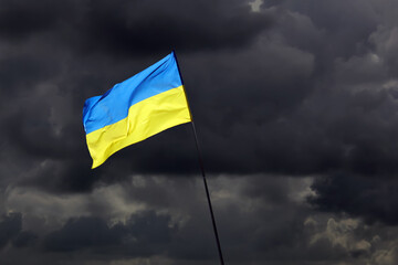 ukraine fahne vor dunklen wolken