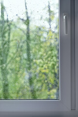 drops water on wet glass background in rainy day. rain outside window. spring summer rainy season....