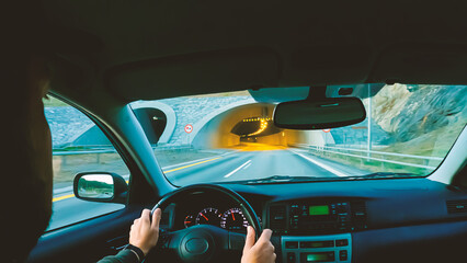 Hands on the wheel when driving at high speed from inside the car. Abstract motion blur.