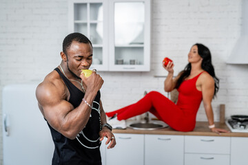 Healthy fit couple eating apples. Sportive couple in sportswear with tasty apple.