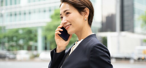 電話をするスーツを着たかっこいい日本人女性