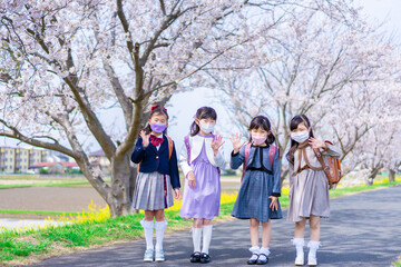 マスクをして小学校に登校する女の子たち