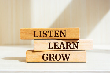 Wooden blocks with words 'Listen, learn, grow'.